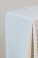 Tissu velours Bubble écru, drapé en angle sur un support, mettant en valeur ses côtes fines.