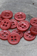 Close-up of the same small four-hole round buttons, highlighting the shine of the material.