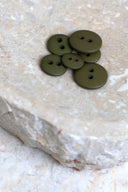 Top-down view of the buttons, stacked at the centre of a marbled beige stone.