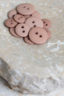 Autre vue rapprochée des boutons sur la pierre beige marbrée, sous un angle différent.