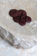 Top-down view of the buttons, stacked at the centre of a marbled beige stone.