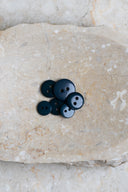Close-up of the same buttons on the edge of a marbled beige stone.