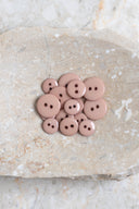 Close-up of the same buttons on the edge of a marbled beige stone.