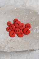 Top-down view of the buttons, stacked at the centre of a marbled beige stone.