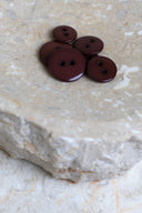 Top-down view of the buttons, stacked at the centre of a marbled beige stone.