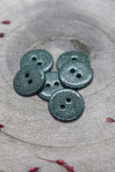 Gros plan sur les boutons entièrement pailletés, vue rapprochée mettant en valeur le grain scintillant de la finition.