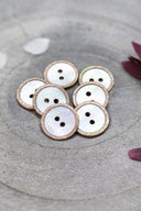 Close-up of the pearly white buttons with a glittery trim, highlighting the sparkle around the edge.