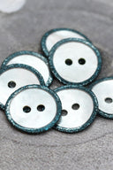 Close-up of the pearly white buttons with a glittery trim, highlighting the sparkle around the edge.
