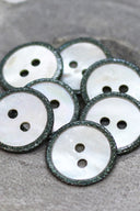 Close-up of the pearly white buttons with a glittery trim, highlighting the sparkle around the edge.
