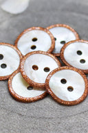 Close-up of the pearly white buttons with a glittery trim, highlighting the sparkle around the edge.