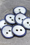 Close-up of the pearly white buttons with a glittery trim, highlighting the sparkle around the edge.