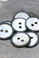 Close-up of the pearly white buttons with a glittery trim, highlighting the sparkle around the edge.