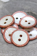 Close-up of the pearly white buttons with a glittery trim, highlighting the sparkle around the edge.
