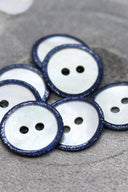Close-up of the pearly white buttons with a glittery trim, highlighting the sparkle around the edge.