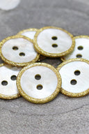 Close-up of the pearly white buttons with a glittery trim, highlighting the sparkle around the edge.