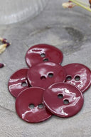 Close-up of the same glossy enamel buttons, revealing the smooth texture and shine of the material.