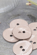 Close-up of the same glossy enamel buttons, revealing the smooth texture and shine of the material.