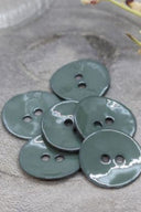 Close-up of the same glossy enamel buttons, revealing the smooth texture and shine of the material.