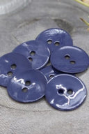 Close-up of the same glossy enamel buttons, revealing the smooth texture and shine of the material.