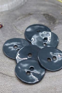 Close-up of the same glossy enamel buttons, revealing the smooth texture and shine of the material.