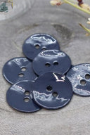 Close-up of the same glossy enamel buttons, revealing the smooth texture and shine of the material.