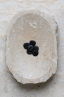 The buttons viewed from above, stacked at the center of a marbled beige stone.