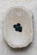 The buttons viewed from above, stacked at the center of a marbled beige stone.