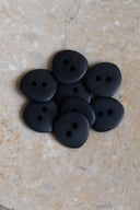 Top-down view of the buttons, stacked at the centre of a marbled beige stone.