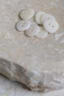 Close-up of the same buttons on the edge of a marbled beige stone.