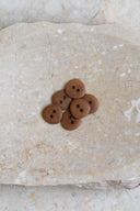 Close-up of the same buttons on the edge of a marbled beige stone.