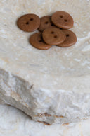Top-down view of the buttons, stacked at the centre of a marbled beige stone.