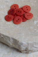 Top-down view of the buttons, stacked at the centre of a marbled beige stone.