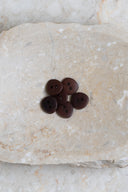 Close-up of the same buttons on the edge of a marbled beige stone.