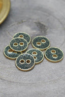 Close-up of the glittered buttons rimmed with a gold trim, highlighting the sparkling texture.