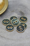 Close-up of the glittered buttons rimmed with a gold trim, highlighting the sparkling texture.