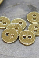 Close-up of the glittered buttons rimmed with a gold trim, highlighting the sparkling texture.