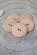 Close-up of the same buttons on the edge of a marbled beige stone.
