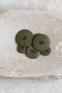 Close-up of the same buttons on the edge of a marbled beige stone.
