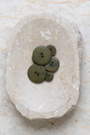 Top-down view of the buttons, stacked at the centre of a marbled beige stone.