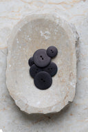 Close-up of the same buttons on the edge of a marbled beige stone.