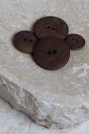 Close-up of the same buttons on the edge of a marbled beige stone.