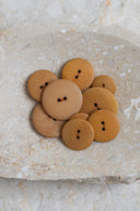 Close-up of the same buttons on the edge of a marbled beige stone.