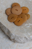 Top-down view of the buttons, stacked at the centre of a marbled beige stone.
