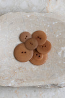 Close-up of the same buttons on the edge of a marbled beige stone.