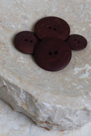 Les boutons vus de dessus, empilés au centre d'une pierre beige marbrée.