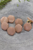 Close-up of the buttons shown from behind, revealing the gold-tone metal shank fastening.
