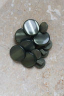 The buttons viewed from above, stacked at the center of a marbled beige stone.