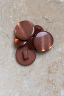 The buttons viewed from above, stacked at the center of a marbled beige stone.