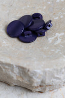 The buttons viewed from above, stacked at the center of a marbled beige stone.