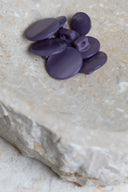 The buttons viewed from above, stacked at the center of a marbled beige stone.